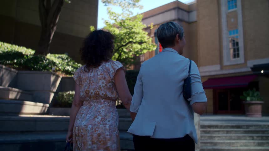 Couple walk holding hand in the city