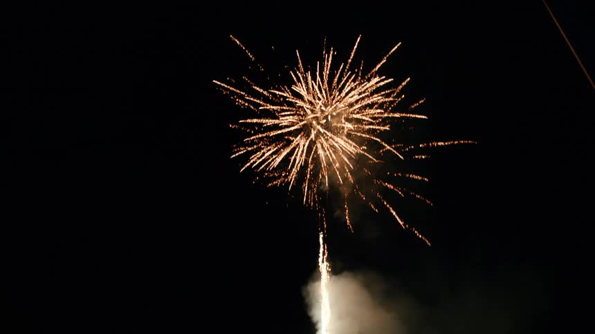 Father holding his child and watching fireworks at night
