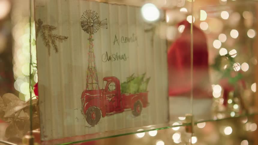 Glass shelves have several small christmas decorations on display