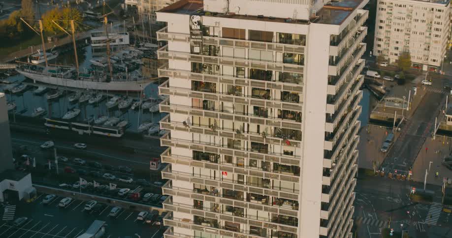Aerial of a building in the city with a flag waving against the wind