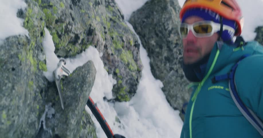 Portrait of a man with climbing stakes ascending a snowcovered mountain