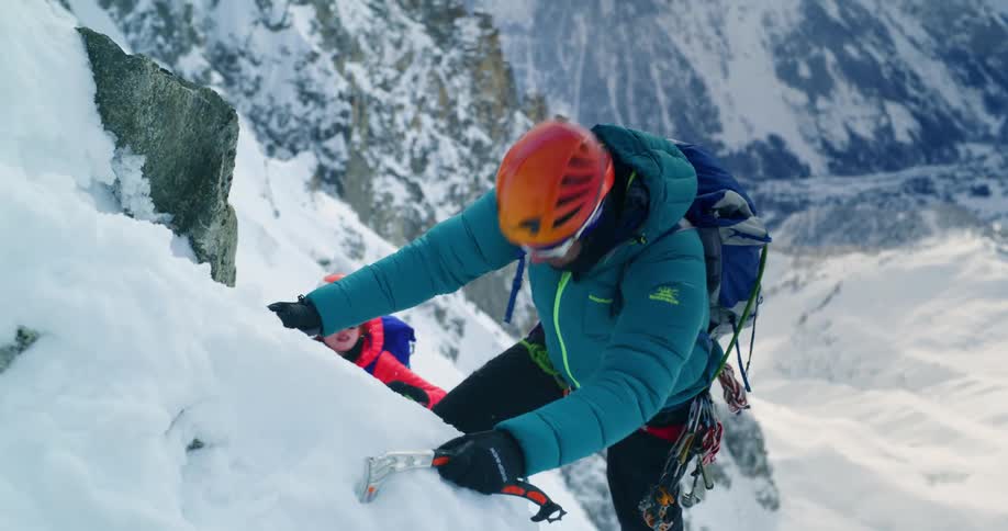 A man is climbing up the snowy mountain