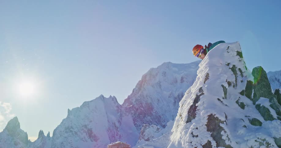 A person reaching the summit of a snowcovered mountain