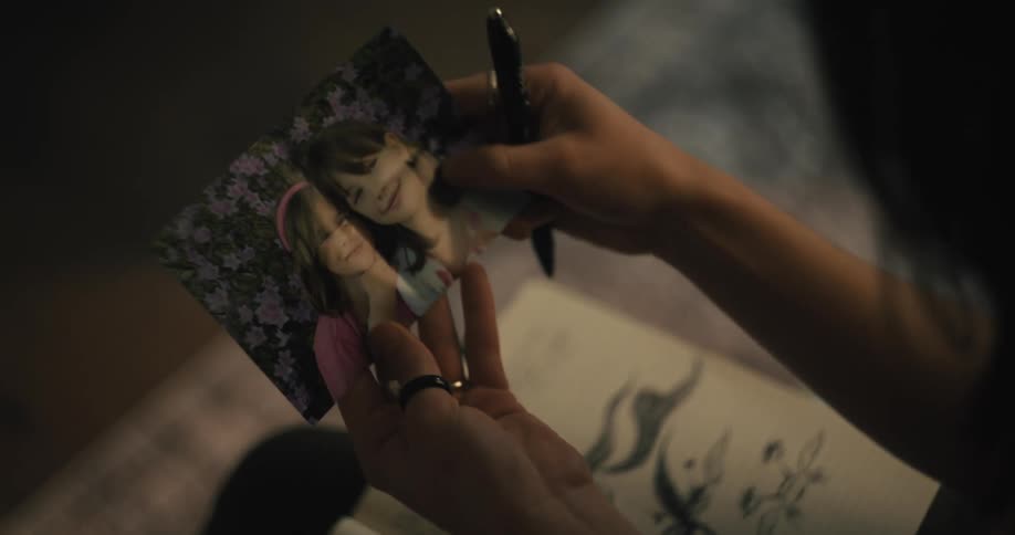 Woman drawing on a notebook finds a folded picture