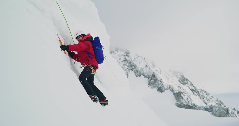 Mountaineer climbing an ice wall in the mountains