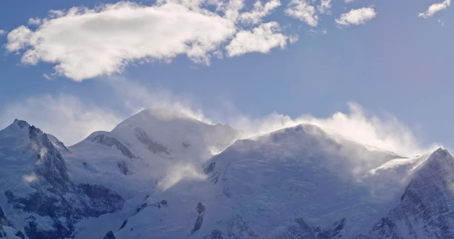 Panorama of a snowcovered mountain range on a day with a blue sky and clouds