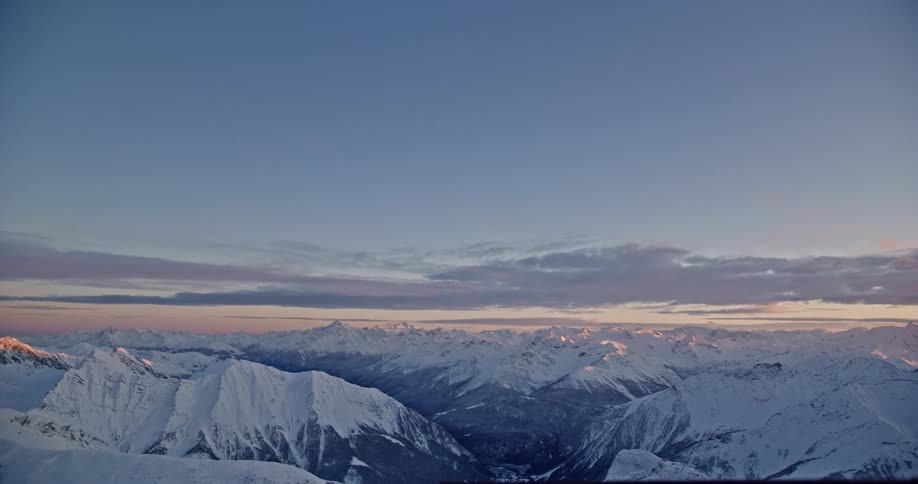 Aerial of snow capped mountain range at dusk