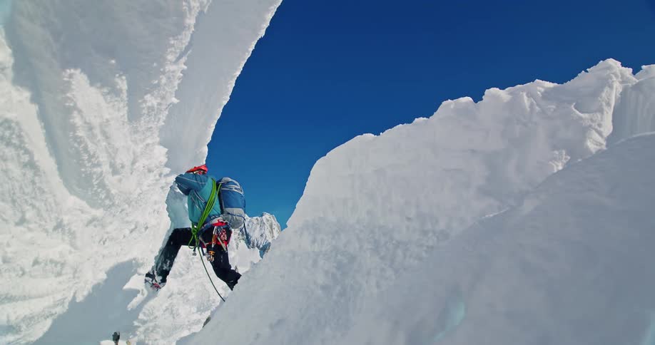 A man is climbing up the snowy mountain