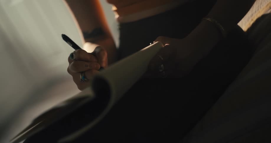 Woman writing on a notepad in the bedroom