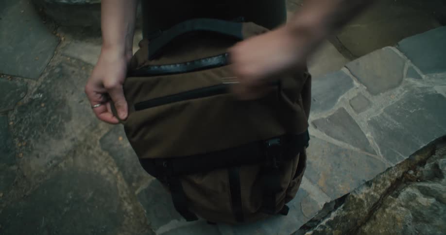 Woman zips close a backpack