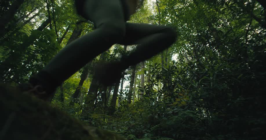 A hiker jumps in the forest