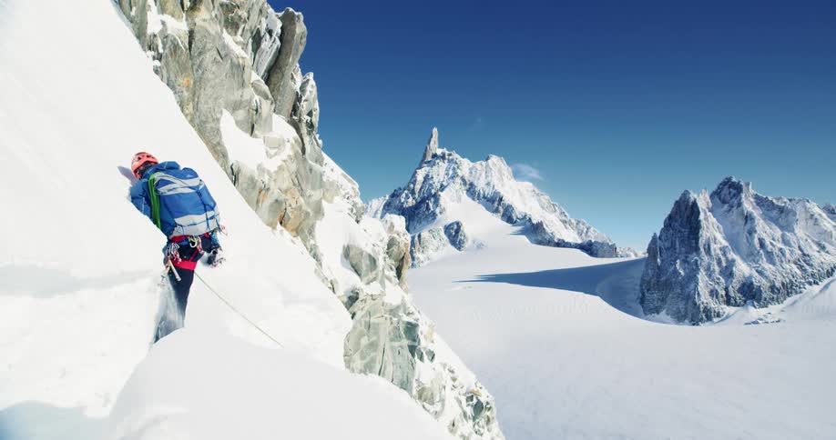 A person with equipment is climbing a snow mountain