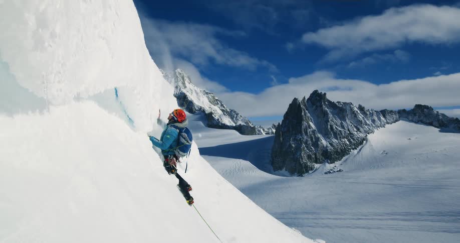 A mountain climber is chopping ice on the mountain