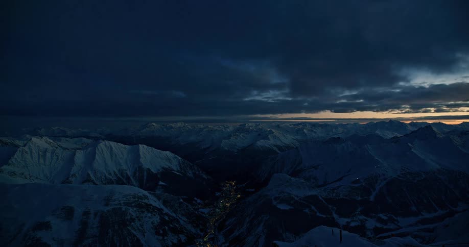 Time lapse of clouds rolling over the snow covered mountains