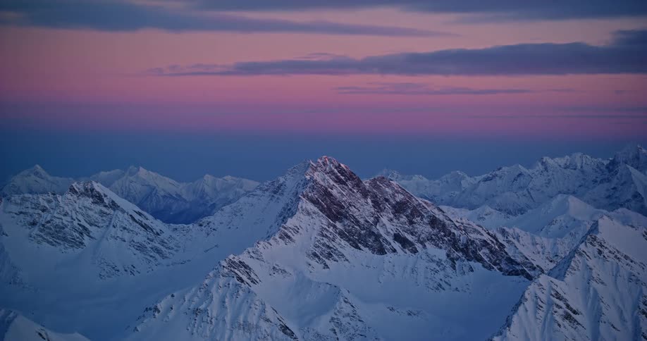 Aerial view of snow capped mountain range at sunset