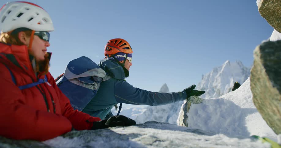 A man reaches out to a bird on the mountain
