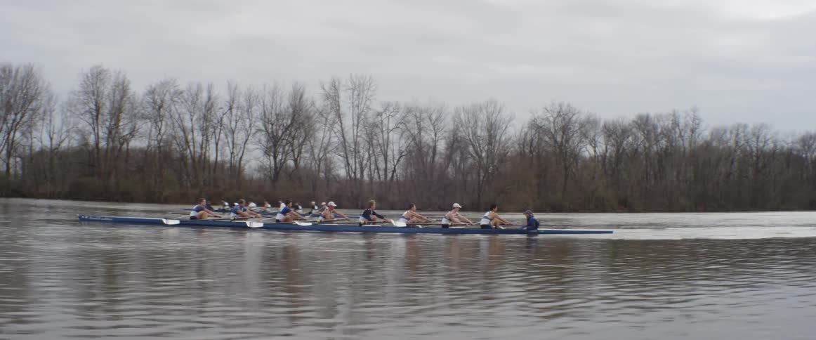 People are racing in long canoes in the water