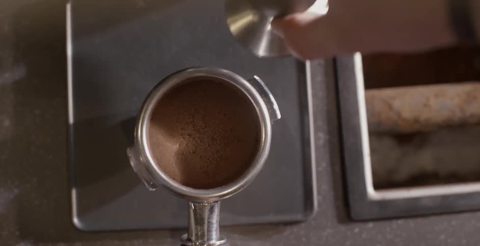 A barista removes a cap to a container