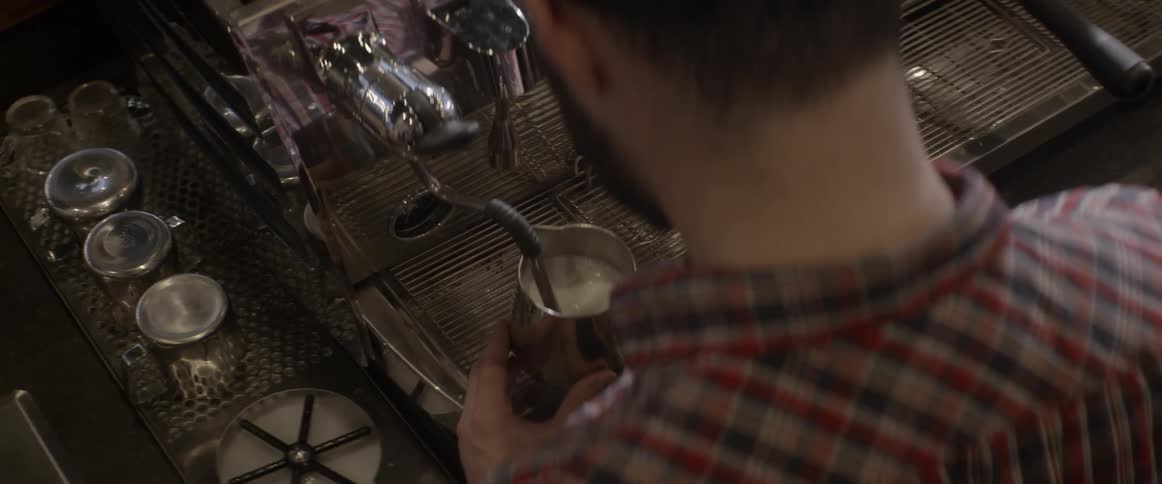 A man makes a latte at a coffee shop