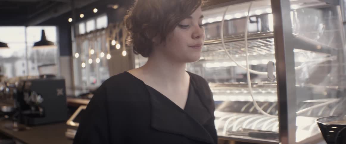 A woman turns back and smiles in a restaurant