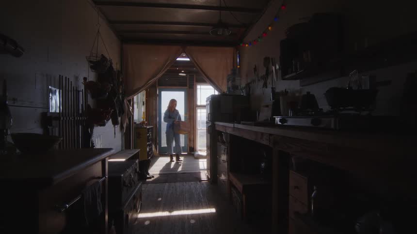 Woman enters room with dog and walks into kitchen