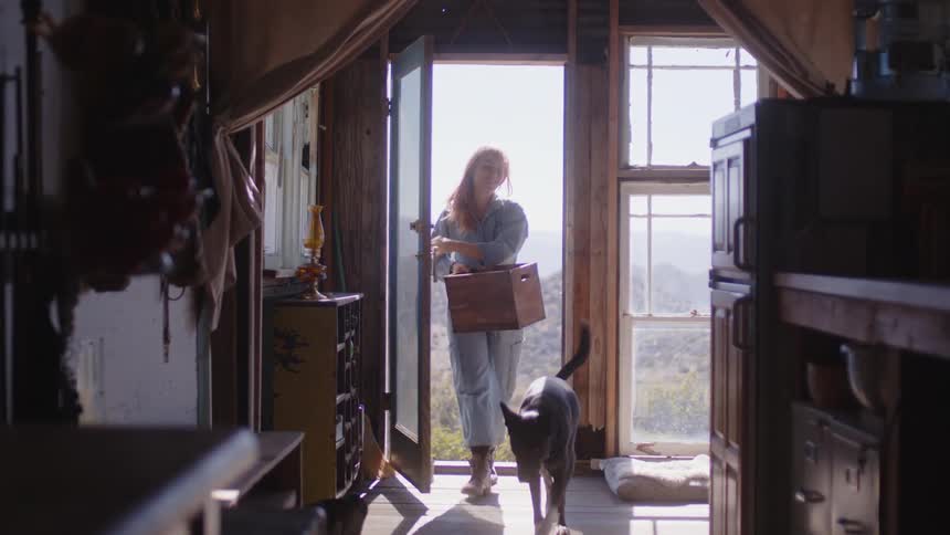 A woman and a dog entering a door in a location