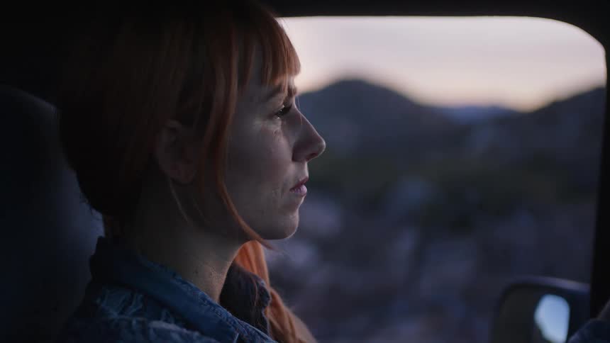 Woman sitting inside a pickup truck in the countryside