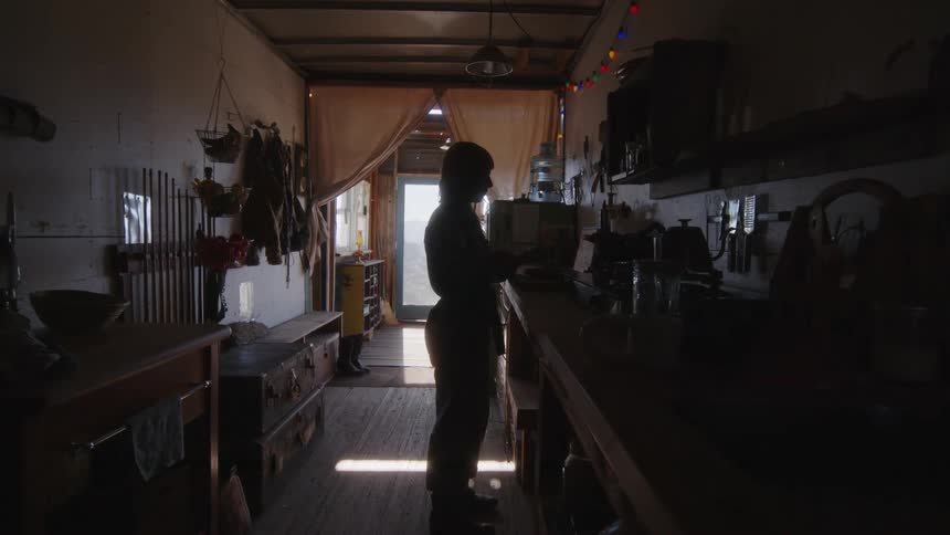 Silhouette of a woman standing in the kitchen of a cabin