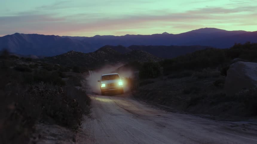 Pickup truck driving on a road through the countryside