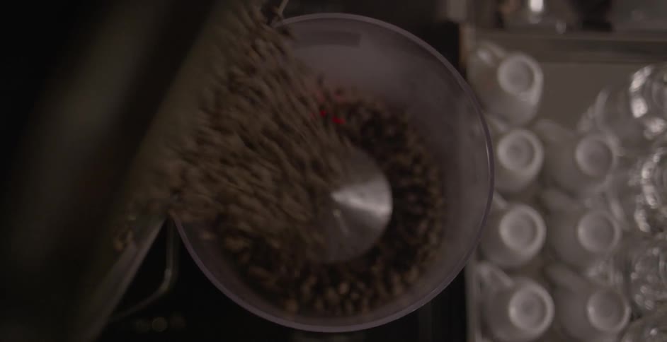 Coffee beans are poured into a container on a scale