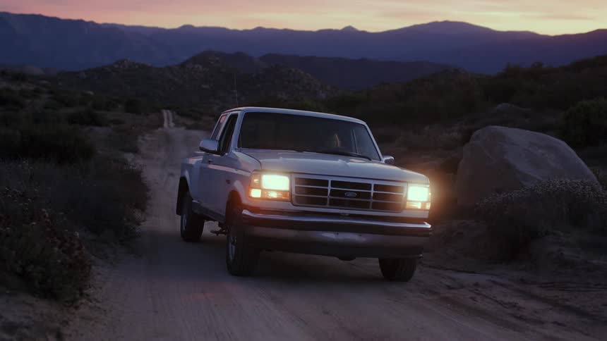 Woman boards a pickup truck and drives away in a rural road