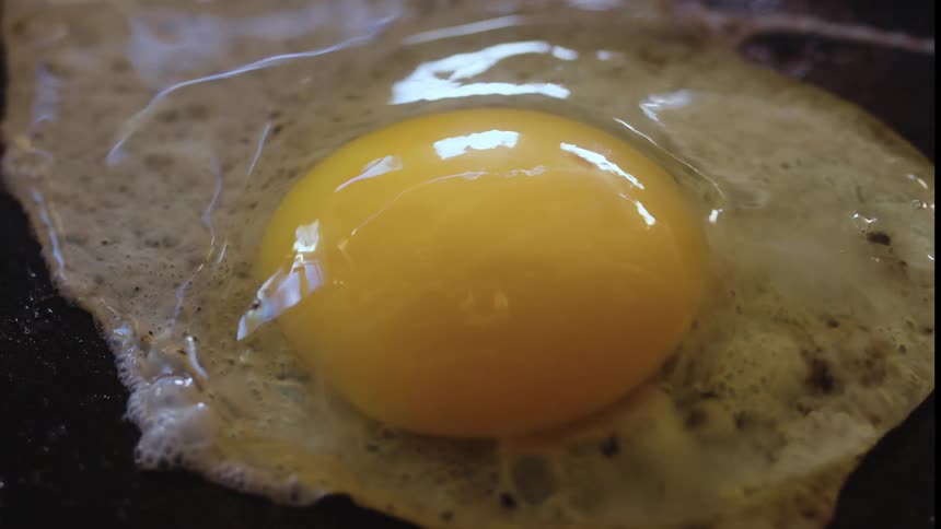 Closeup of a frying pan with an egg being fried