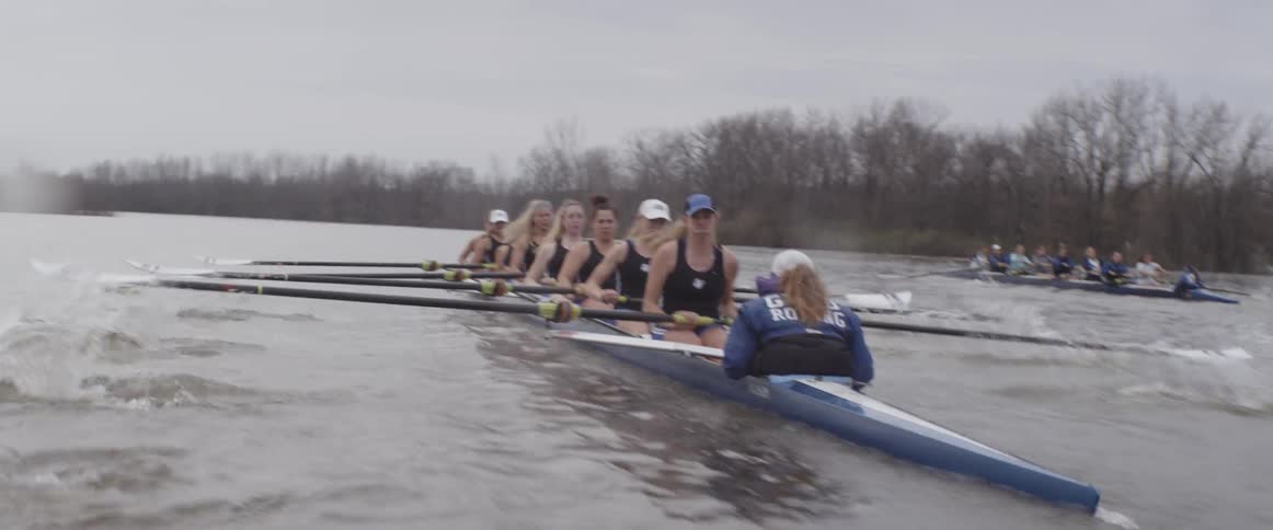 Female rowing teams compete on an overcast day
