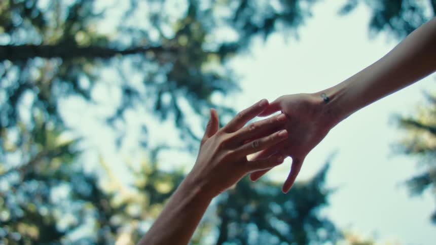 Two hands from two different people trying to reach each other but failing in a performance