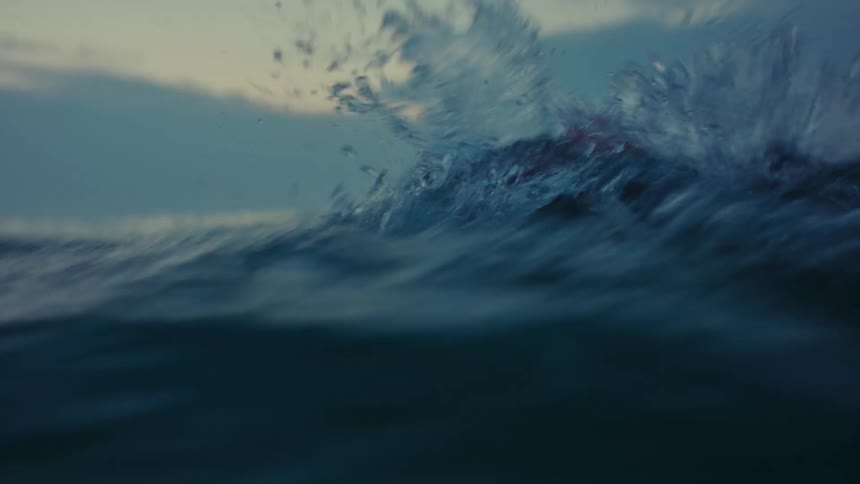 Close up of a man swimming in the ocean at sunset