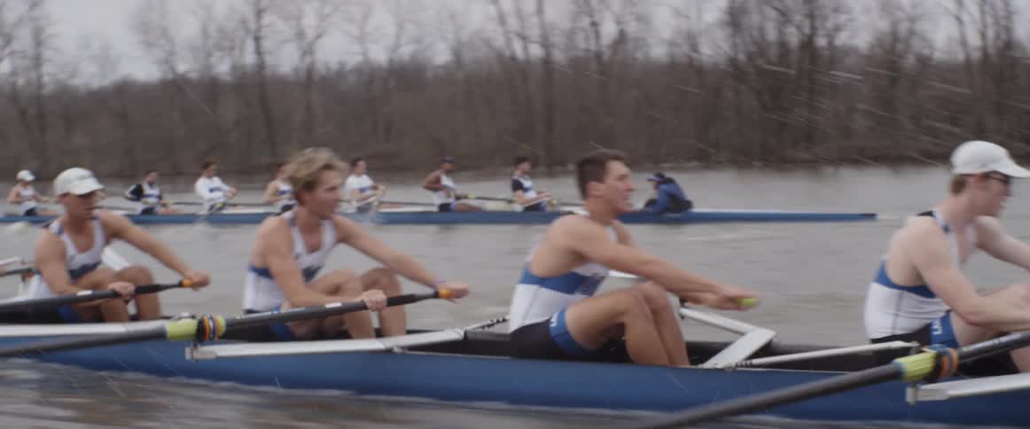 Two rowing teams race down a river