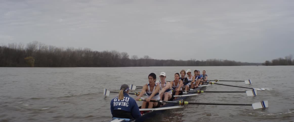 A rowing team rows on an overcast day