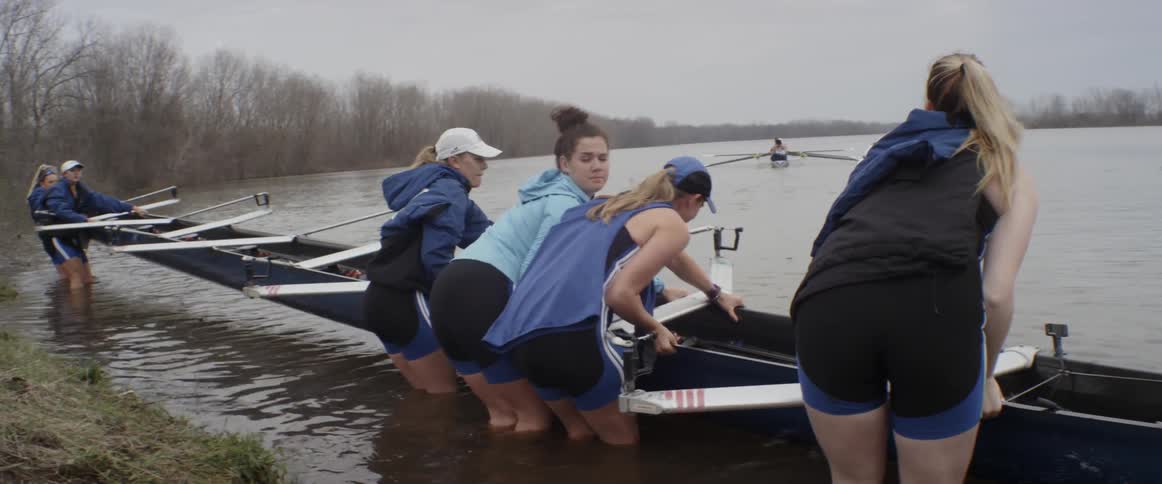 Four woman turn over a boat and set it on water