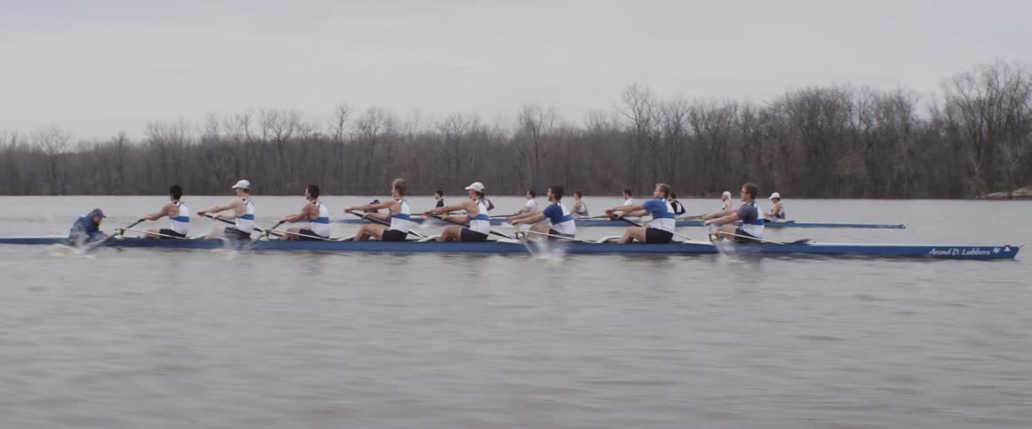Two rowing teams race down a river
