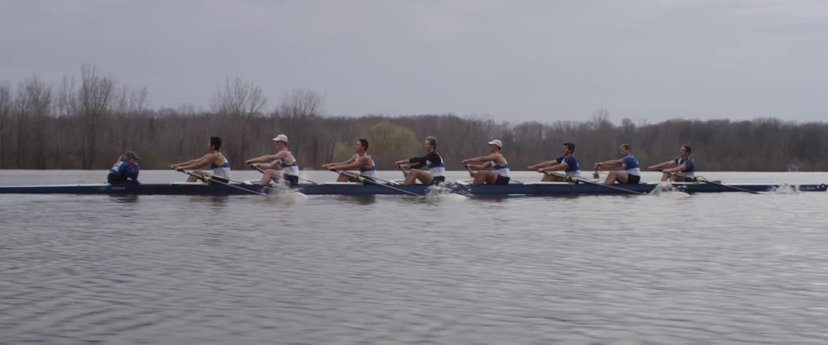 A team of men are racing a sculled boat