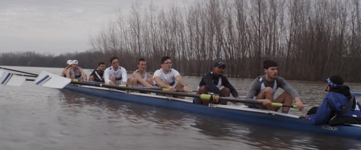 People row together racing in a boat