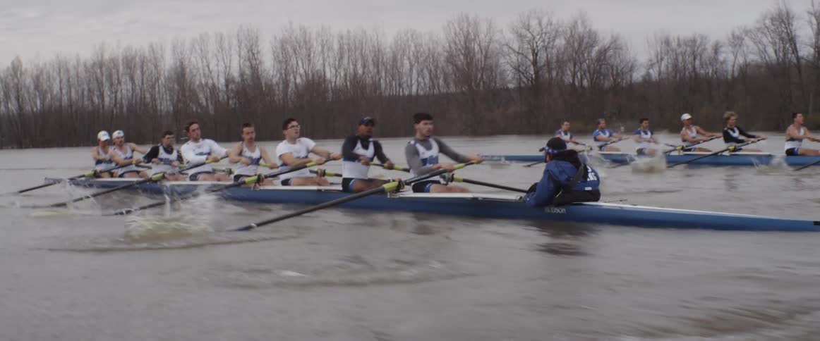 Two rowing teams race down a river