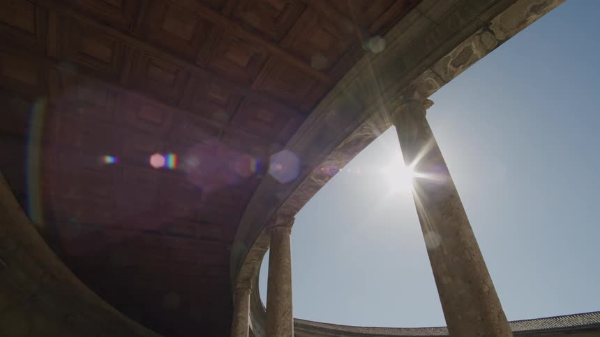 Sun shines behind a column on a classical building