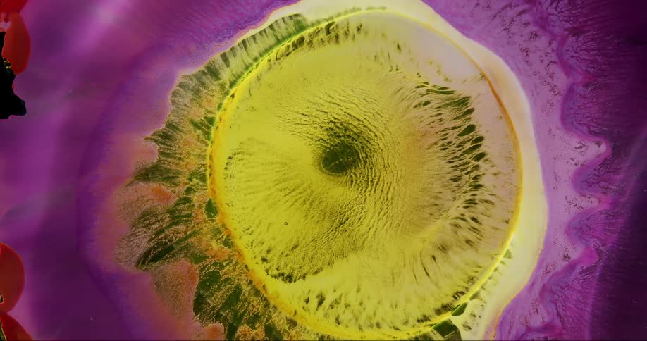 Extreme closeup of an abstract drop of colored ink fluid expanding