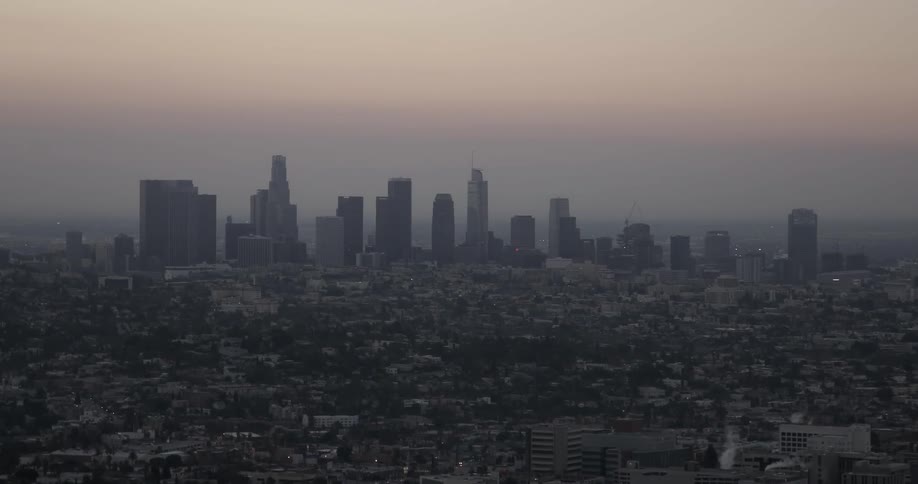 Steam rises off of a building in a city skyline