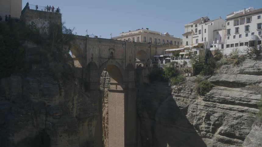 Panorama of a bridge amidst an urban and rustic city in daylight with a blue sky and no clouds