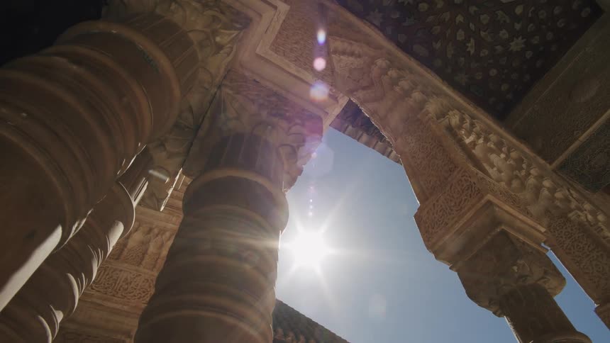Sunlight shines through the columns of a building