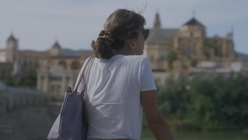 Woman with her back turned overlooking monasteries on a day with a blue sky