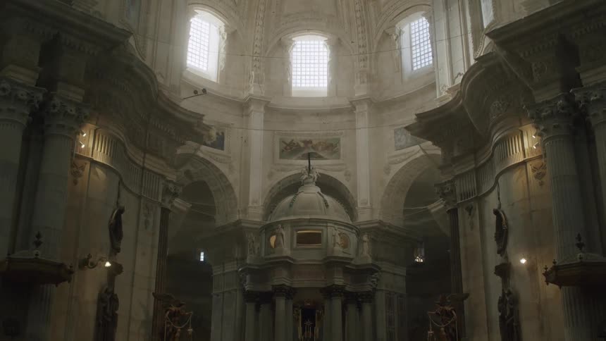 Windows set in domed ceiling let in light onto detailed architectural decor of cathedral interior