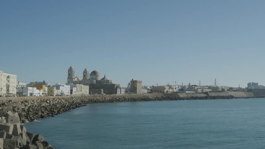 Panorama of a lake on the edge of an urban city during a day with a cloudless blue sky